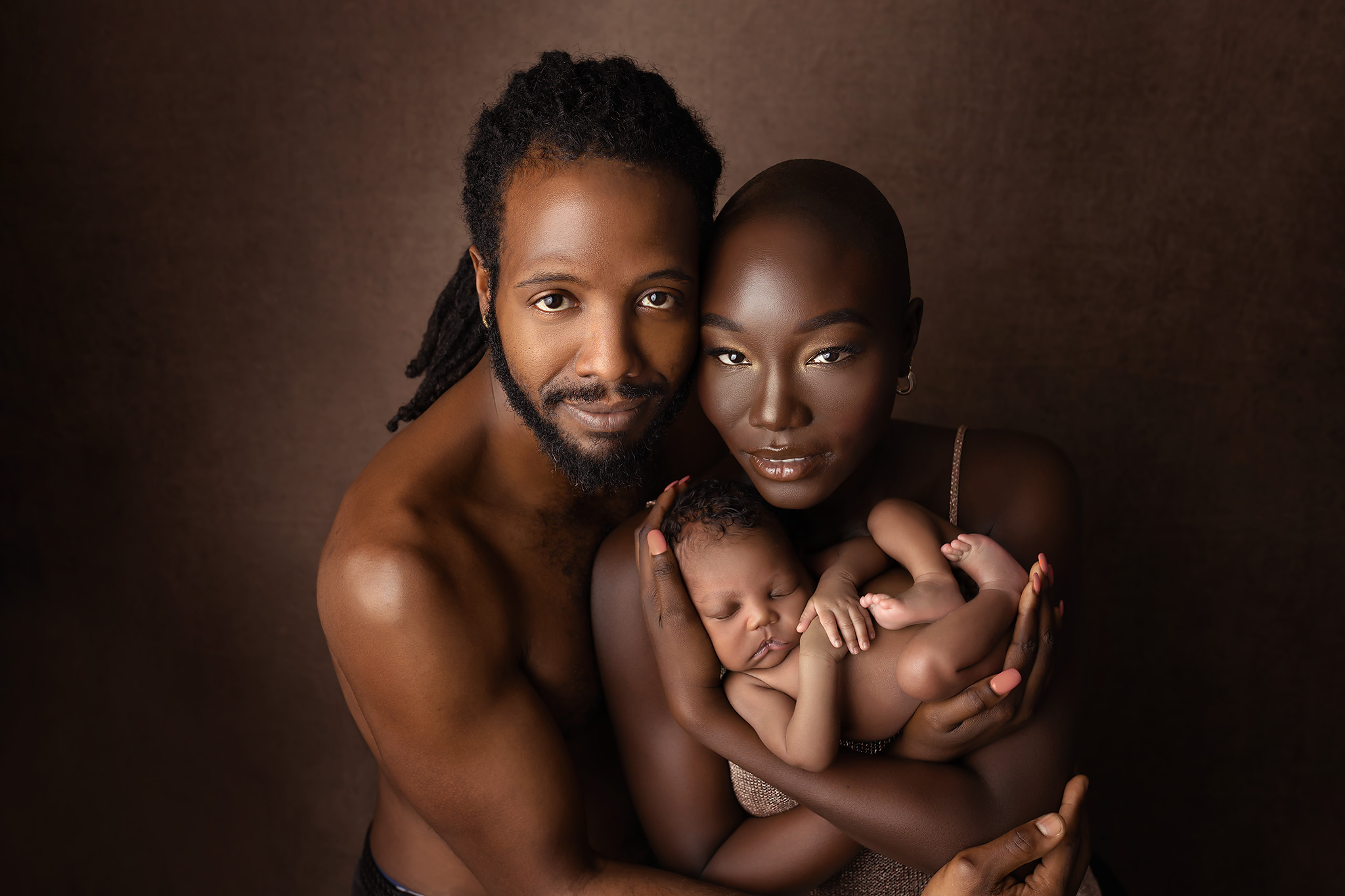 Stunning family photo including a newborn in warm tones and focused on When to Book Newborn Photos in Dallas