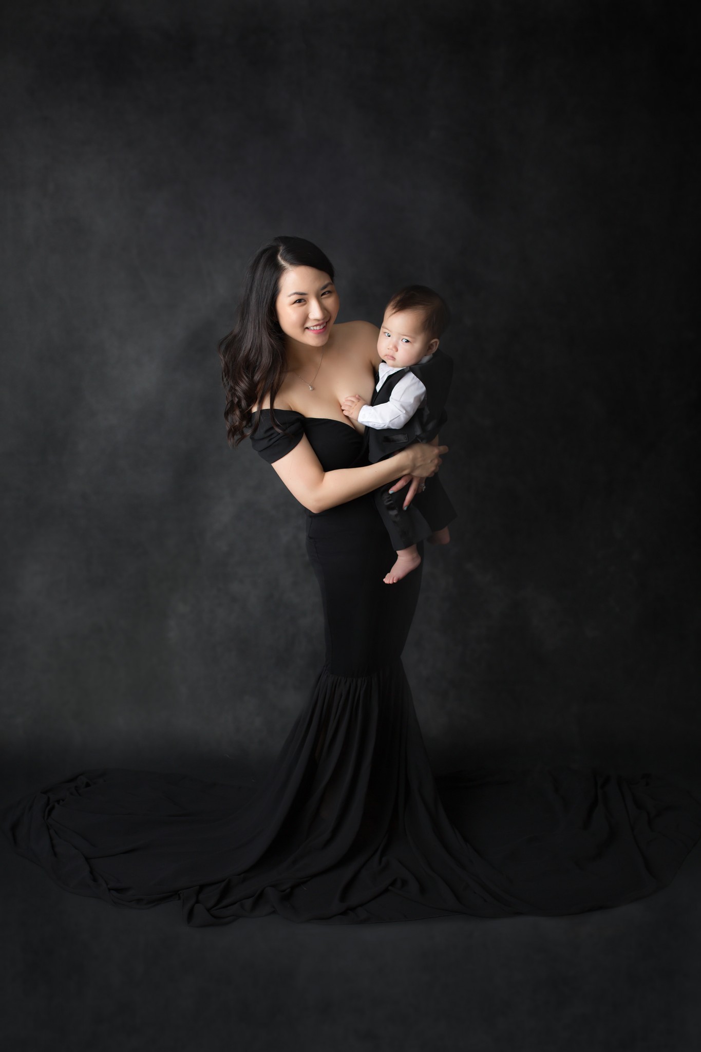 Mother in black dress holding son