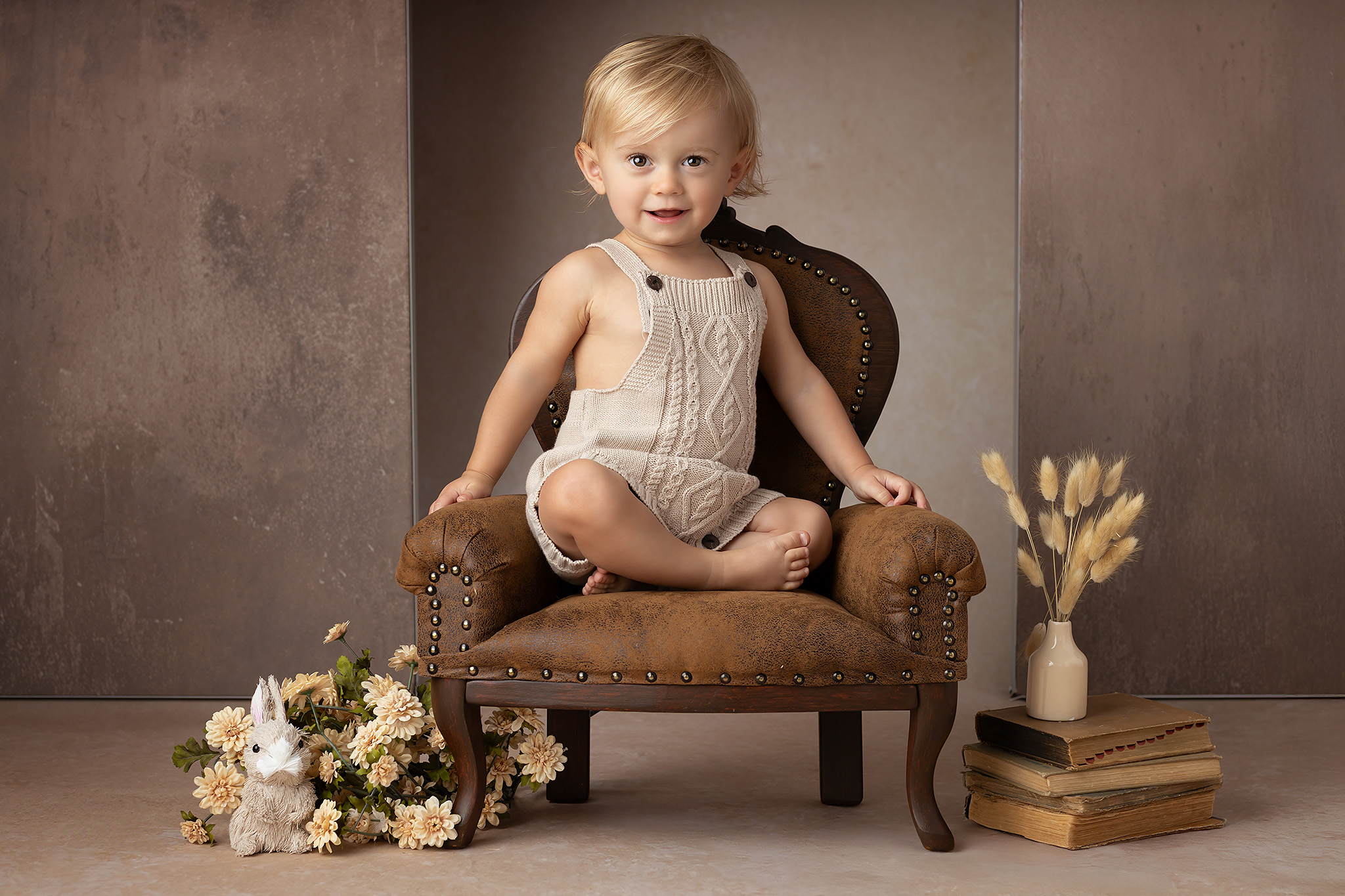 One year old photo session with a blonde baby boy sitting in a luxurious leather chair, the perfect High End Photographer Dallas photo for a milestone.