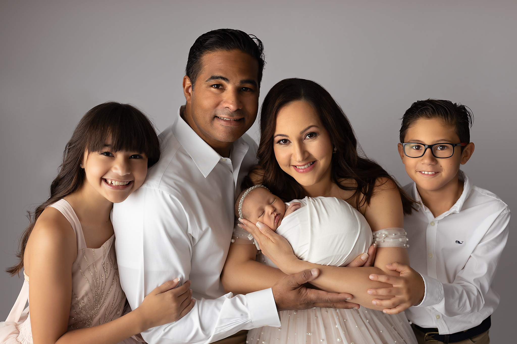 A beautiful family photo of 5 with everyone wearing white