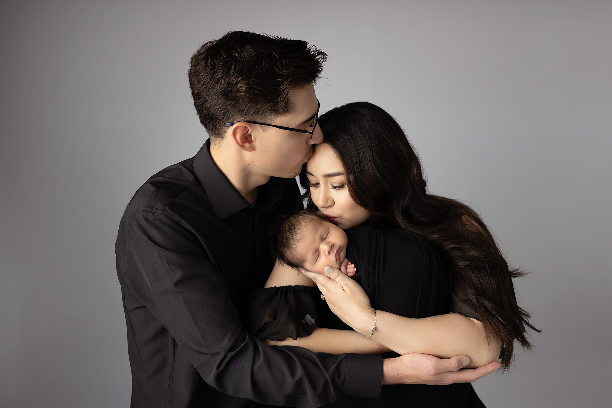 Beautiful newborn family photos of a family in all black elegantly styled