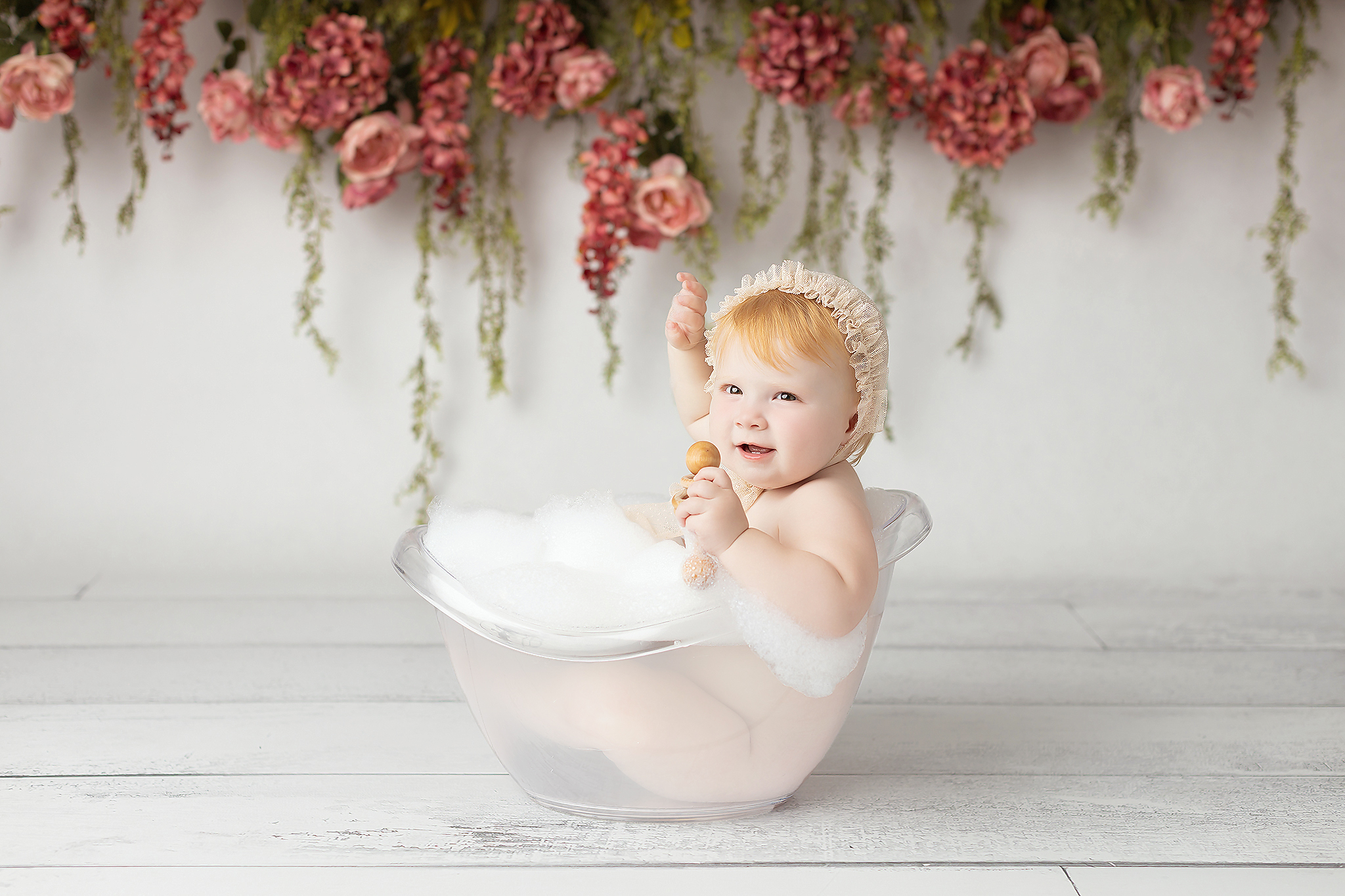 Cute one year milestone photo of baby girl in a bubble bath surrounded by flowers showing items on a Baby registry guide for Dallas parents