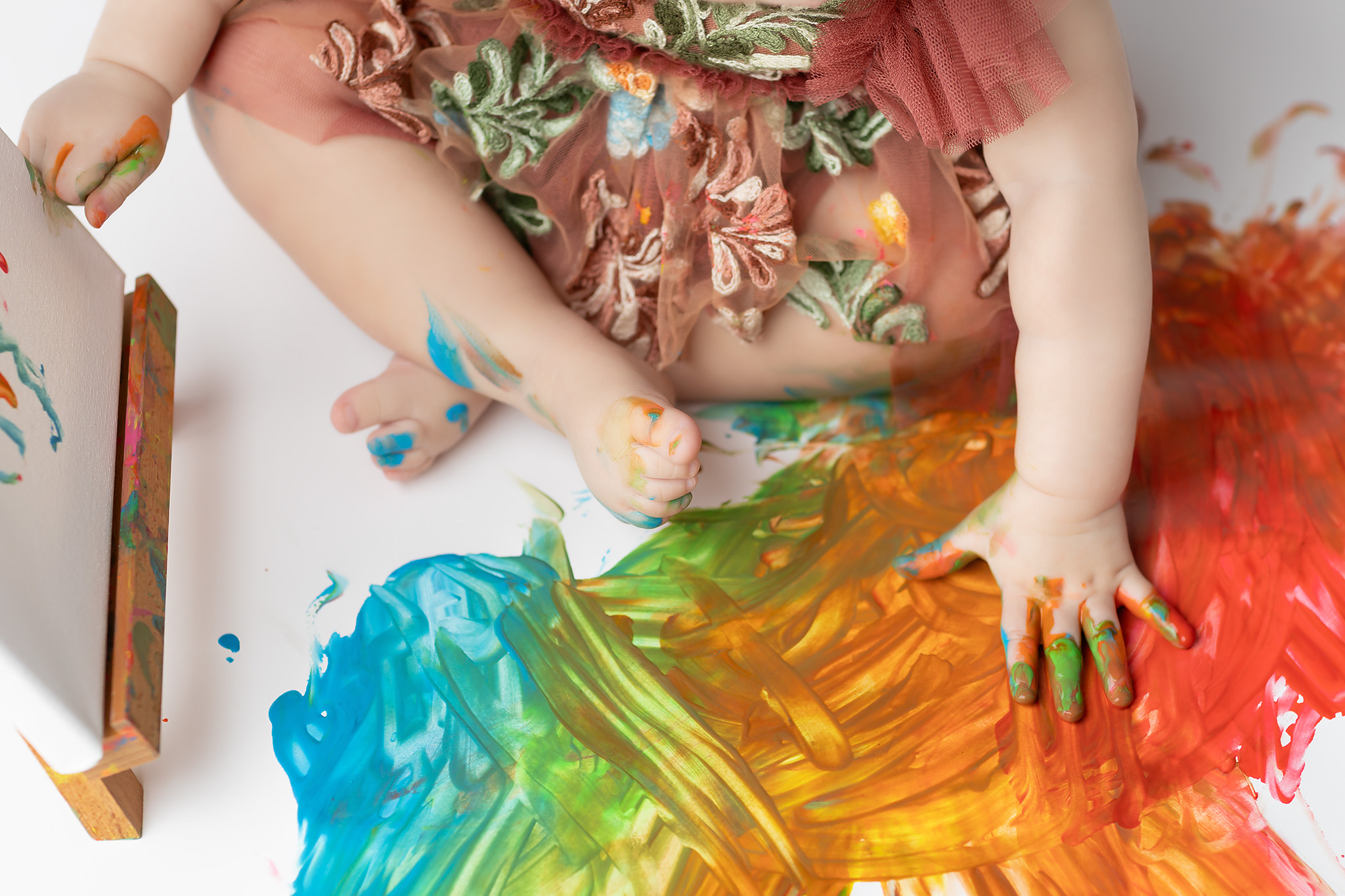 Baby playing with paint.